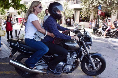 El ya exministro de Finanzas griego, Yanis Varoufakis, y su mujer, Danae Stratou, encima de una moto a la puerta de su casa, en Atenas.-Foto:   AFP / LOUISA GOULIAMAKI