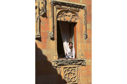 Pilar Fernández de Trocóniz, en la denominada Ventana del Obispo, que corona el patio del Castillo del Buen Amor, con su tinto CBA. En la foto pequeña, los viñedos que rodean el Castillo del Buen Amor, con la torre del homenaje al fondo.-ARGI