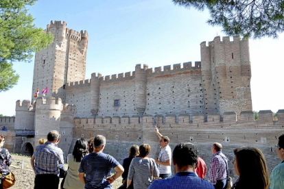 Un grupo de visitantes atiende al guía en el Castillo de La Mota, una de las paradas de la ‘Ruta de Fernando’.-Santiago