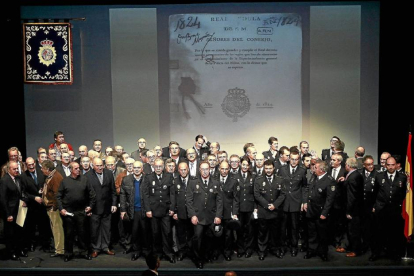 Foto de familia de los policías distinguidos con diplomas, medallas, cruces, encomiendas y placas en el escenario del teatro Zorrilla-J.M.Lostau