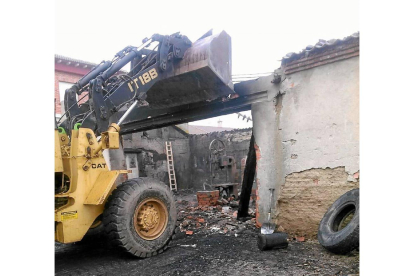 Una excavadora derriba el inmueble calcinado en la noche del martes en la calle Estación de Ataquines-El Mundo