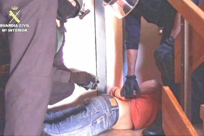 Guardias Civiles inmovilizan a uno de los detenidos en un piso de la calle Hermanos Cossío de Huerta del Rey.-E.M