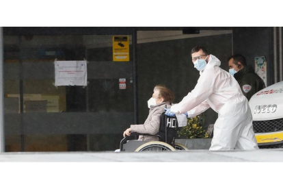 Una mujer es trasladada en silla de ruedas al Hospital Clínico de Valladolid en la mañana de ayer. J.M. LOSTAU