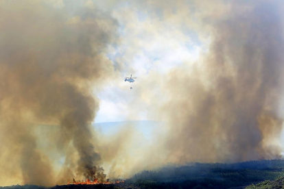 Un helicóptero durante las labores de extinción  del incendio que desde el lunes permanece activo en Encinedo, en la comarca de La Cabrera..-ICAL