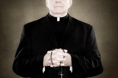 Un sacerdote sujeta un rosario.-EL PERIÓDICO