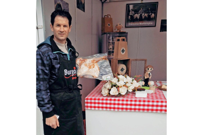 Sergio Lázaro en la pasada edición de la feria con una de las piezas de lechazo que vende a los visitantes. / ECB