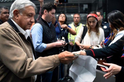 Andrés Manuel López Obrador, presidente de México, recoge su billete de avión antes de embarcar en un vuelo comercial en el aeropuerto internacional de México el 15 de febrero del 2019.-ALFREDO ESTRELLA (AFP)