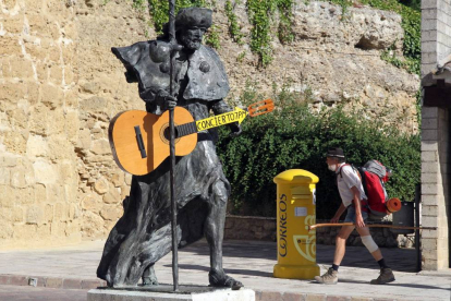 Un peregrino pasa junto al monumento a Santiago en Carrión de los Condes (Palencia)-Ical