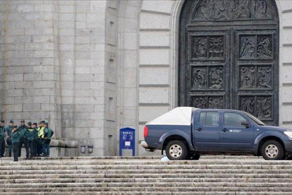 Un grupo de guardias civiles de los que han realizado preparativos esta mañana en la basílica del Valle de los Caídos, habla a la puerta de la basílica de la Santa Cruz junto a un coche de operarios de Patrimonio Nacional.-JOSÉ LUIS ROCA