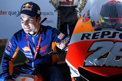 Dani Pedrosa se ha fotografiado hoy, en Valencia, el día de su adios, con una moto de juguete y su Honda RC213V nº 26.-AFP / JOSÉ JORDAN