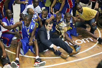 El técnico vallisoletano posa con su equipo con la Copa de campeón con el Maxaquene de Maputo. / EL MUNDO