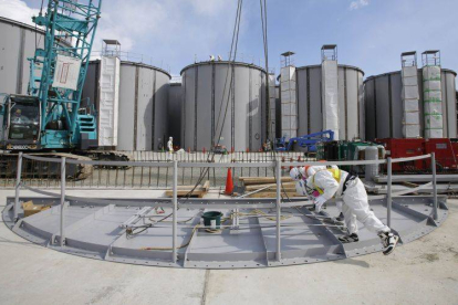 Dos operarios trabajan ante unos tanques de agua de Fukushima.-Foto: REUTERS / TORU HANAI