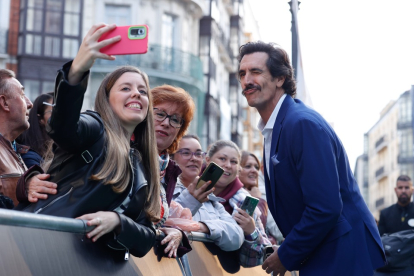 Rodrigo Poison se hace una fotografía con una espectadora en la alfombra verde inaugural de la 68 Seminci. -SEMINCI