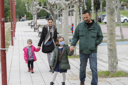 Padres pasean a sus hijos cerca del río en Valladolid. -JUAN MIGUEL LOSTAU