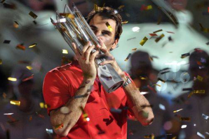 Roger Federer besa el trofeo que lo acredita como ganador del Master 1.000 de Shanghái.-Foto: AFP / JIA RU