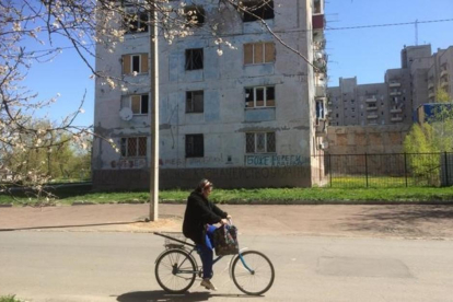 Una mujer pasa frente a un edificio afectado por los bombardeos en Avdiivka.-MARC MARGINEDAS