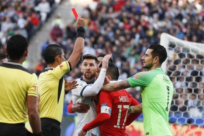 El colegiado muestra la tarjeta roja a Messi y Medel.-AP / VICTOR R. CAIVANO