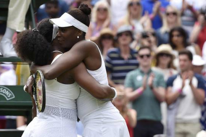 Serena (izquierda) y Venus Williams se abrazan tras el partido de octavos de final de Wimbledon, que ha acabado con victoria de la menor de las hermanas.-REUTERS / TOBY MELVILLE