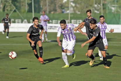 Un jugador del Almería agarra a Miguel para evitar que se lleve el balón en el partido disputado ayer en Marbella.-JOSÉ LUIS SOBREDO / PHOTO-DEPORTE