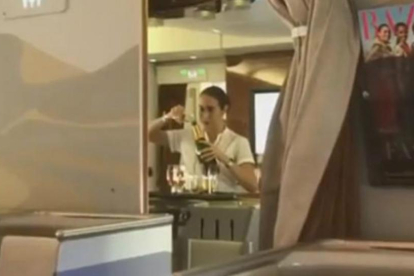Captura del vídeo en el que se ve a la azafata de Emirates rellenando una botella de champán con restos de copas usadas.-YOUTUBE