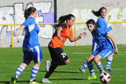 Carolina Birizamberri se lleva el balón ante la presencia de dos jugadoras del UBU.-ISRAEL L. MURILLO