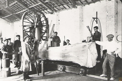 Obreros de la desaparecida serrería de la plaza de San Nicolás en los años 30 del siglo pasado. Aparecen manejando maquinaria para serrar un tronco de grandes dimensiones. ARCHIVO MUNICIPAL