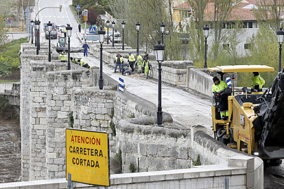 Operarios y máquinas toman ayer posesión del puente medieval de Cabezón en el arranque de la intervención que durará nueve meses. J.M.- LOSTAU