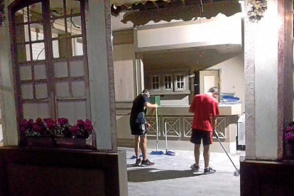 Dos miembros de La Molinera limpian el interior del hotel.-TWITTER