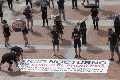 Varias personas colocan la pancarta en medio de la plaza Mayor para exigir soluciones para el sector de la hostelería. MIGUEL ÁNGEL SANTOS / PHOTOGENIC