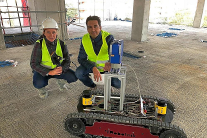 Los investigadores Rocío Fernández Mora y Diego González Aguilera muestran el robot que certifica el avance en las obras.-EL MUNDO