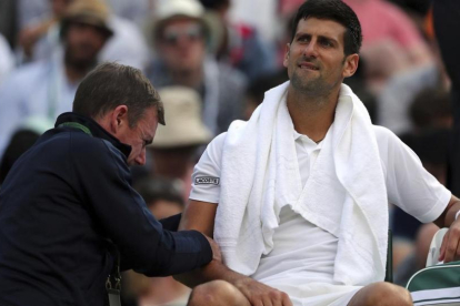 Djokovic recibe tratamiento en el codo en su partido ante Berdych en Wimbledon-AP / GARETH FULLER