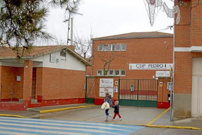 Una madre y su hijo pasan por delante del colegio Pedro I de Tordesillas, uno de los eliminados del programa.-Santiago