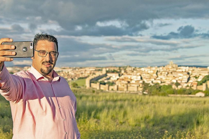 Daniel López se hace un ‘selfie’ desde lo alto de los Cuatro Postes, en Ávila, con la ciudad al fondo como panorámica.-ARGICOMUNICACIÓN