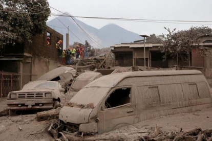 Bomberos y personal de rescate inspecciona los destrozos causados por el volcán de Fuego en Escuintla, Guatemala.-REUTERS (LUIS ECHEVERRÍA)