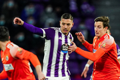 Javi Sánchez intenta abrirse paso entre dos rivales, en el último Real Valladolid-Burgos.