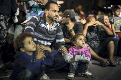 Un padre sirio y sus hijos espera para subir al ferry en la isla griega de Lesbos.
AFP / ACHILLEAS ZAVALLIS