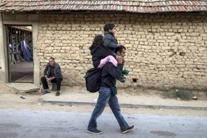 Un refugiado sirio camina por Miratovac con un niño en sus hombros.
REUTERS / MARKO DJURICA