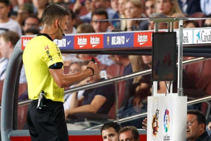 Gil Manzano chequea la jugada que condujo a la expulsión de Lenglet, en el Barça-Girona de Liga.-REUTERS / ALBERT GEA