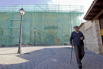 Un vecino de Villalba pasea por la plaza donde se ubica el BIC, ya cubierto para su remodelación-J.M.Lostau