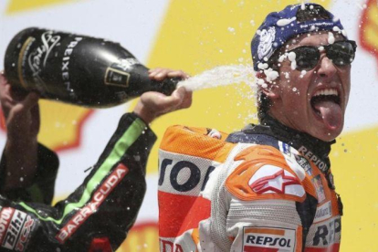 Johann Zarco (Yamaha) ducha a Marc Márquez (Honda), en el podio de Sepang (Malasia).-AP / VICENT PHOON