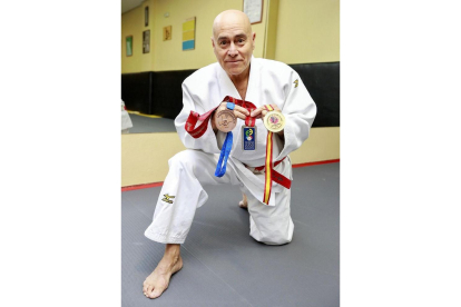 Julio Cereijo posa con las medallas nacionales e internacionales conseguidas sobre el tatami.-J.M. LOSTAU