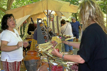 Una visitante consulta el precio de una de las piezas en una feria de artesanía.-ICAL