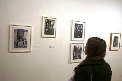 Una mujer contempla algunas de las fotografías de Luskacová.-ICAL