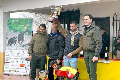 El equipo ganador posa con la galga ‘Flecha’, la copa recibida y el alcalde de la villa, Guzmán Gómez.-EL MUNDO