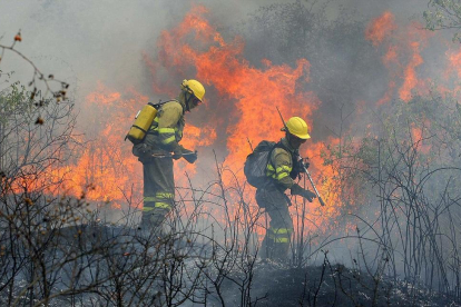 Dos brigadistas trabajan en las labores de extinción de un incendio, en una imagen de archivo.-ICAL