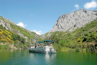 Una embarcación surca las aguas en el embalse de Riaño.