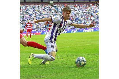 Toni Villa, a punto de caer al suelo tras una entrada de un jugador del Granada el pasado martes.-J.M. LOSTAU