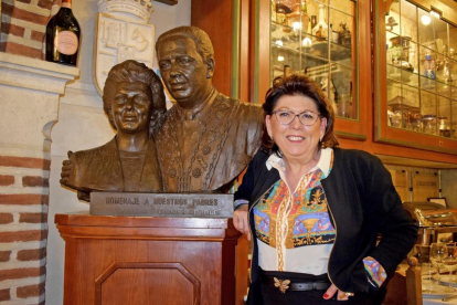 Marisa Duque, junto al busto de bronce de sus padres, situado en el interior del mesón segoviano.-ARGICOMUNICACIÓN
