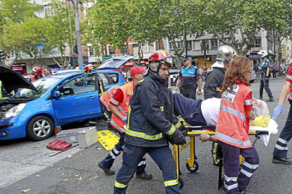 Momento en el que los servicios de rescate evacuan al ocupante que quesdó atrapado en el Opel Astra.-J.M. Lostau