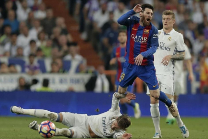 Sergio Ramos, en el suelo delante de Messi, en el clásico del pasado mes de abril.-AP / DANIEL OCHOA DE OLZA